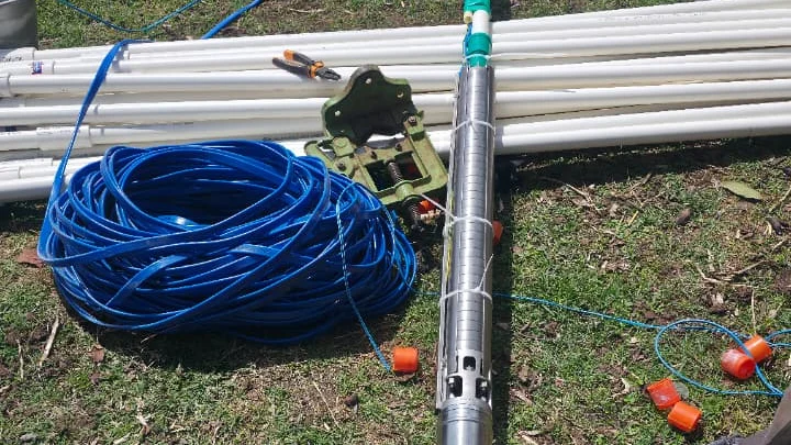 Submersible pump, rising main and drop cable laid out for inspection before reinstallation